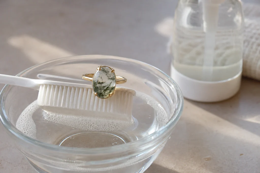Cleaning a moss agate engagement ring with mild soap and a soft brush